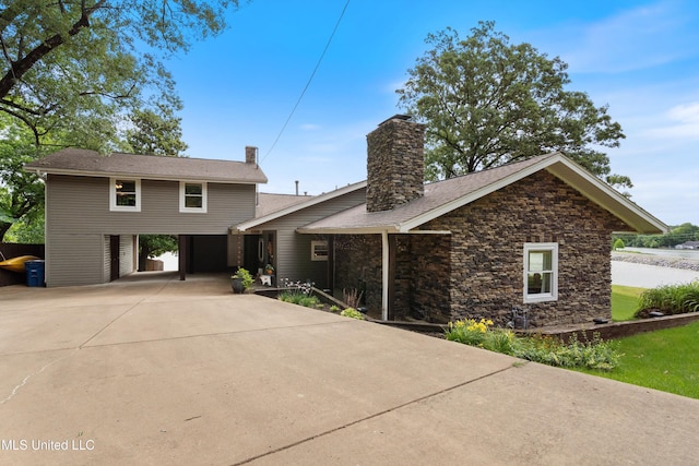 7300 W Shahkoka Dr, Olive Branch, MS 38654 - view of front of property with concrete driveway, a chimney, and stone siding