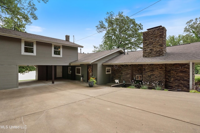 7300 W Shahkoka Dr, Olive Branch, MS 38654 - view of front facade with a chimney, concrete driveway, and a carport