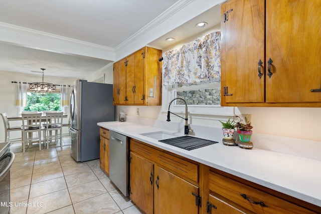 7300 W Shahkoka Dr, Olive Branch, MS 38654 - kitchen featuring appliances with stainless steel finishes, a sink, brown cabinets, light countertops, and ornamental molding