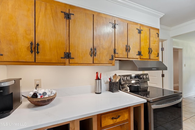 7300 W Shahkoka Dr, Olive Branch, MS 38654 - kitchen with stainless steel electric range oven, under cabinet range hood, ornamental molding, brown cabinets, and light countertops