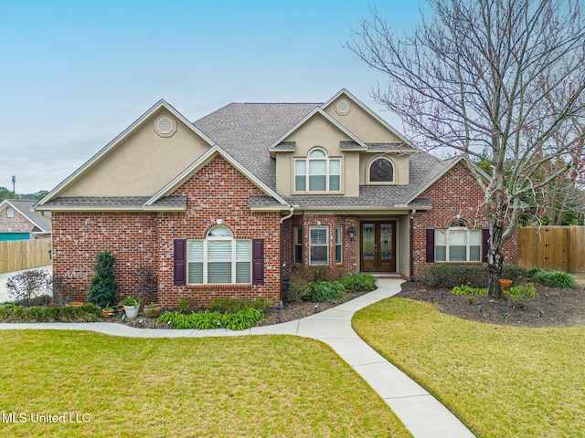 view of front property with french doors and a front lawn