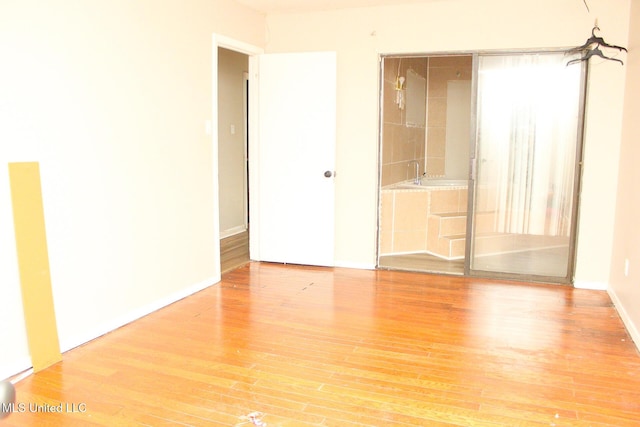 unfurnished room with wood finished floors and baseboards