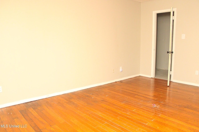 empty room with baseboards and wood finished floors