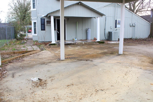 rear view of house featuring fence and central AC