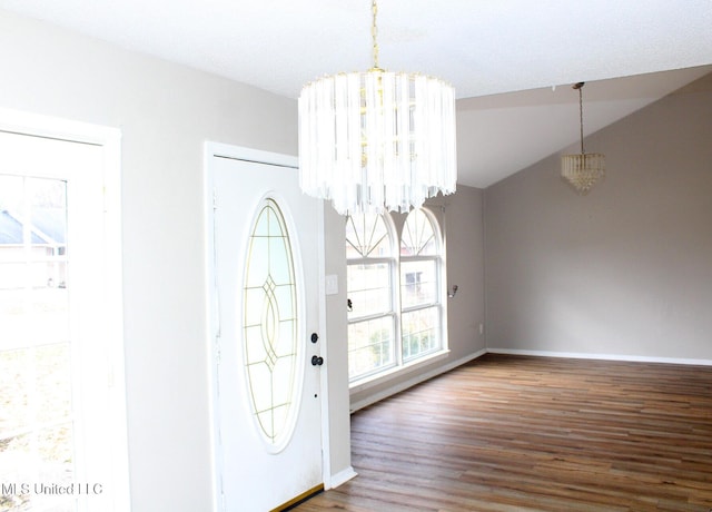 entrance foyer featuring baseboards, vaulted ceiling, a notable chandelier, and wood finished floors