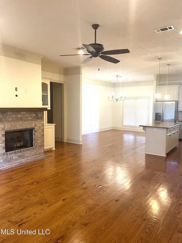 unfurnished living room featuring ceiling fan, visible vents, and dark wood-style floors