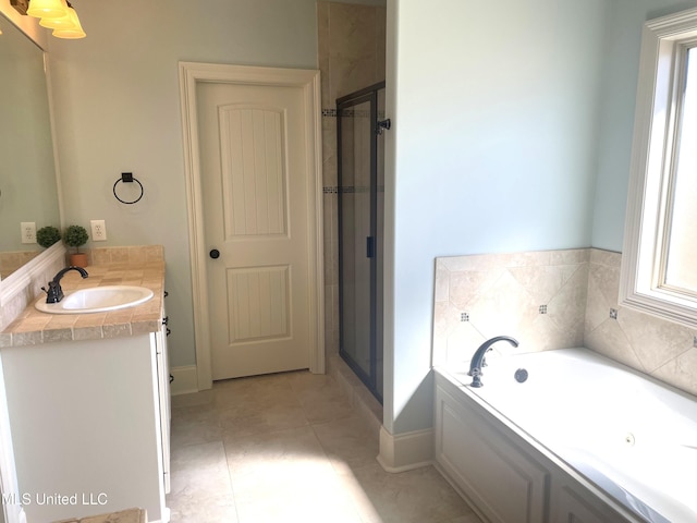 bathroom with a garden tub, a stall shower, vanity, and tile patterned flooring