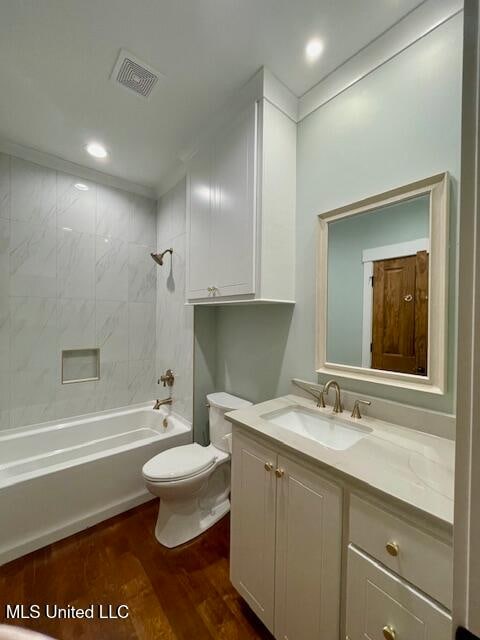 full bathroom with hardwood / wood-style floors, vanity, toilet, and tiled shower / bath