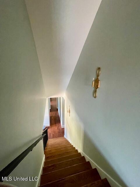 stairs with lofted ceiling and wood-type flooring