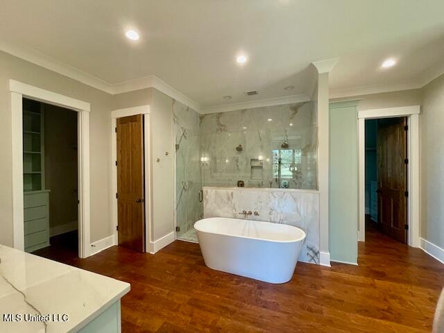 bathroom with crown molding, independent shower and bath, and hardwood / wood-style flooring