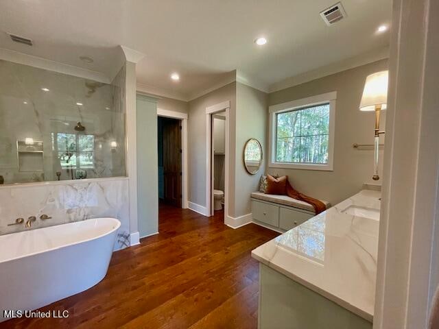 bathroom featuring a tub, hardwood / wood-style floors, vanity, and ornamental molding