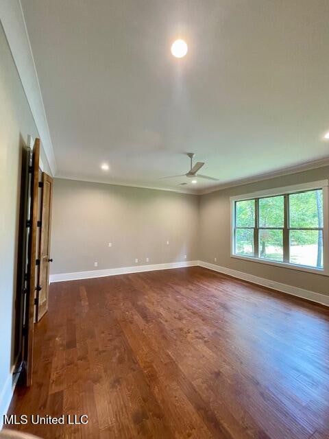 unfurnished room with crown molding, ceiling fan, and dark wood-type flooring