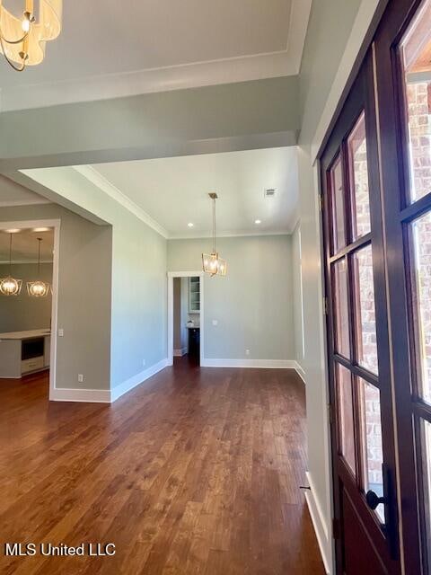 unfurnished room with crown molding, dark hardwood / wood-style flooring, and a notable chandelier