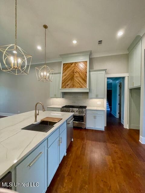 kitchen featuring pendant lighting, crown molding, sink, light stone counters, and dark hardwood / wood-style flooring