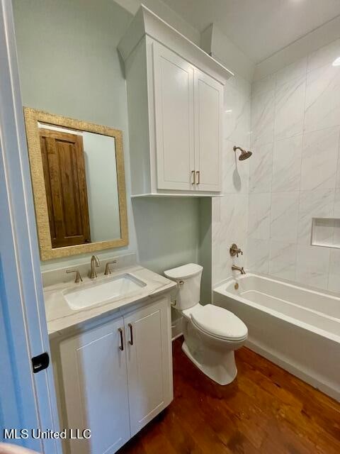 full bathroom with vanity, wood-type flooring, tiled shower / bath combo, and toilet