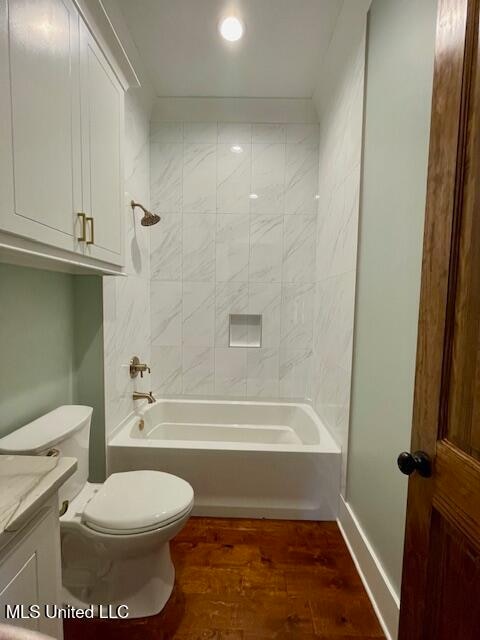 full bathroom with wood-type flooring, vanity, toilet, and tiled shower / bath