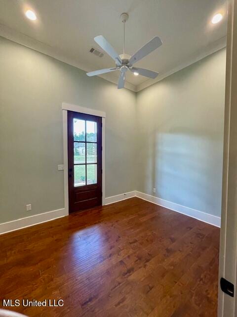 empty room featuring dark hardwood / wood-style floors, ceiling fan, and ornamental molding