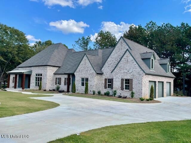 french country home with a front yard and a garage