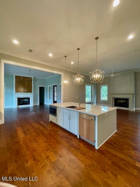 kitchen featuring appliances with stainless steel finishes, sink, dark hardwood / wood-style floors, white cabinetry, and an island with sink