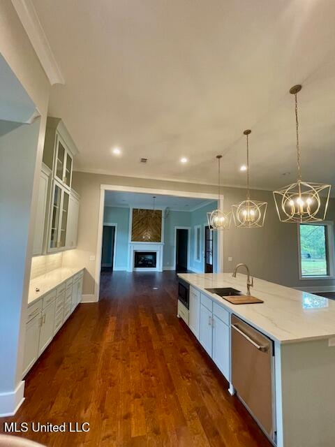 kitchen with dark wood-type flooring, dishwasher, white cabinets, and pendant lighting