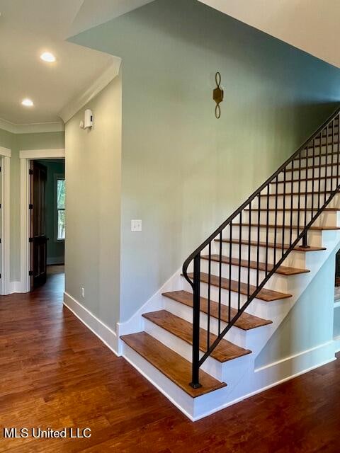 stairs with wood-type flooring and crown molding