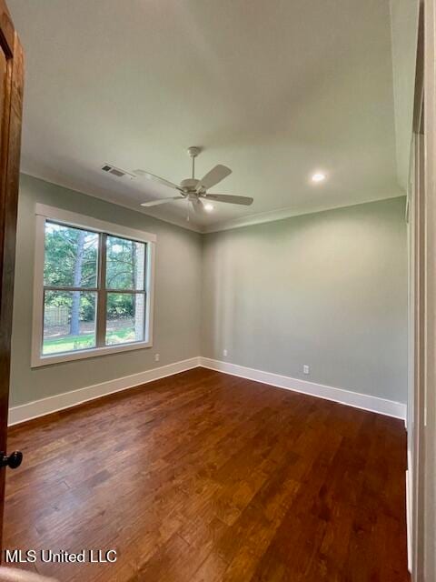 spare room with ornamental molding, ceiling fan, and dark wood-type flooring