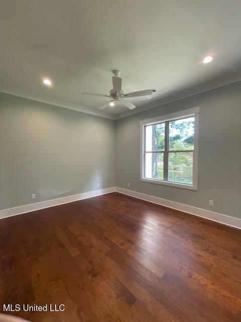 unfurnished room featuring dark hardwood / wood-style flooring, ceiling fan, and ornamental molding