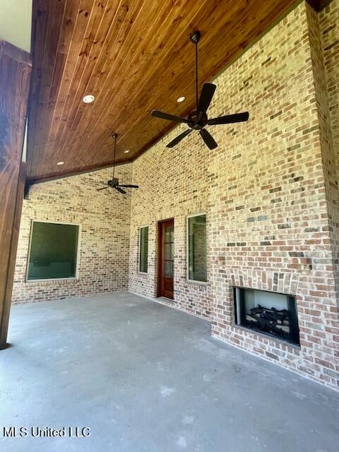 view of patio with a large fireplace and ceiling fan