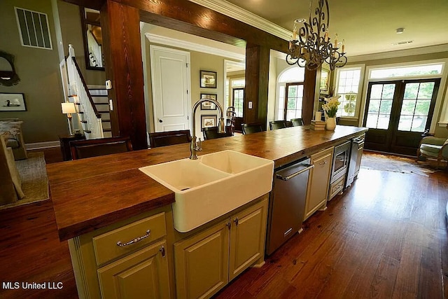 kitchen with a sink, wood counters, visible vents, open floor plan, and crown molding