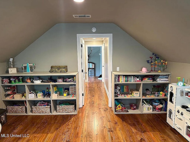 playroom featuring vaulted ceiling, wood finished floors, and visible vents