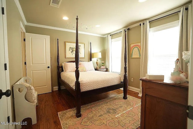 bedroom featuring visible vents, crown molding, baseboards, and wood finished floors