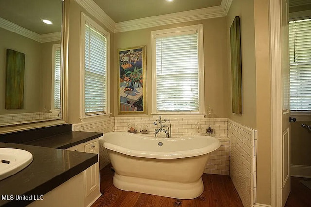 full bathroom featuring crown molding, a freestanding bath, and wood finished floors