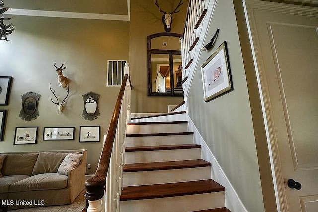 stairs featuring baseboards, visible vents, and crown molding