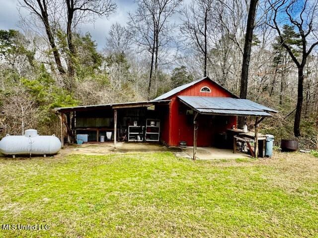 view of pole building with a carport and a yard