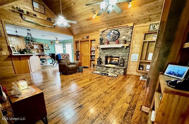 living room featuring light wood-type flooring, wood walls, and a fireplace