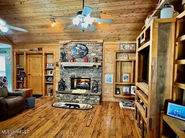 living room with a ceiling fan, lofted ceiling, wooden ceiling, wood finished floors, and a fireplace