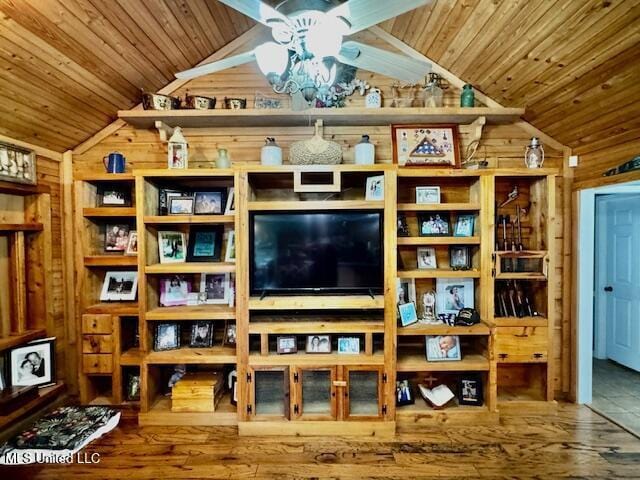 living area with wood ceiling, vaulted ceiling, and wooden walls