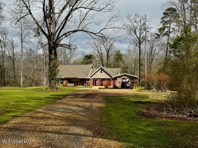 view of front facade with a front yard, driveway, and a detached carport