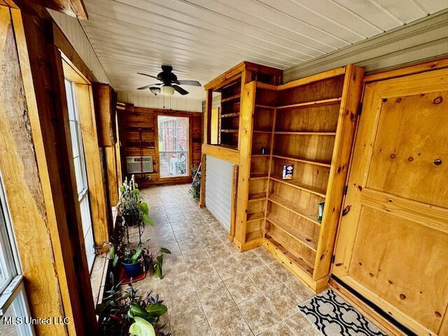 interior space with wooden ceiling, a wall mounted air conditioner, wood walls, and light tile patterned floors