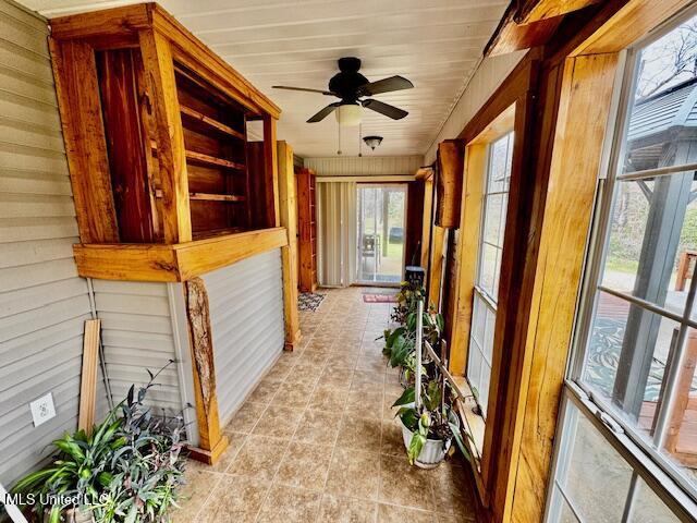 unfurnished sunroom with ceiling fan