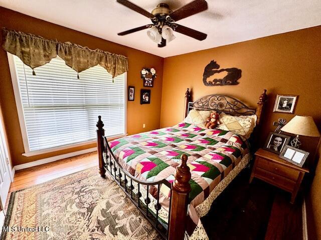 bedroom featuring a ceiling fan and wood finished floors