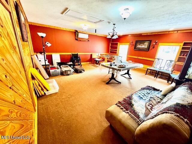 playroom featuring a wall unit AC, carpet, and attic access