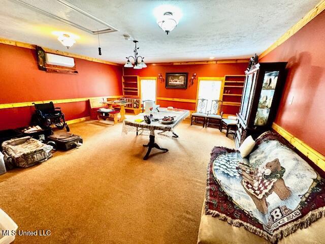 rec room with a wall unit AC, carpet, attic access, and baseboards