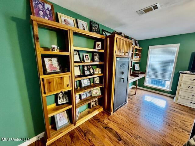 interior space featuring baseboards, visible vents, and wood finished floors