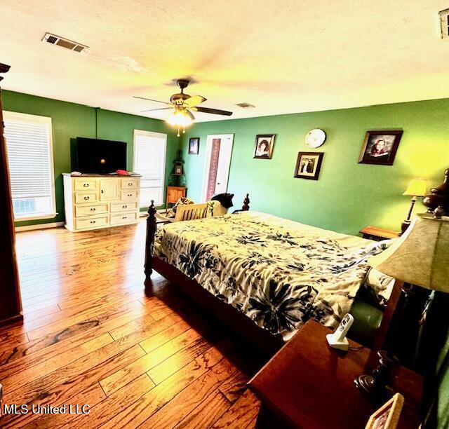 bedroom with visible vents, light wood finished floors, and multiple windows