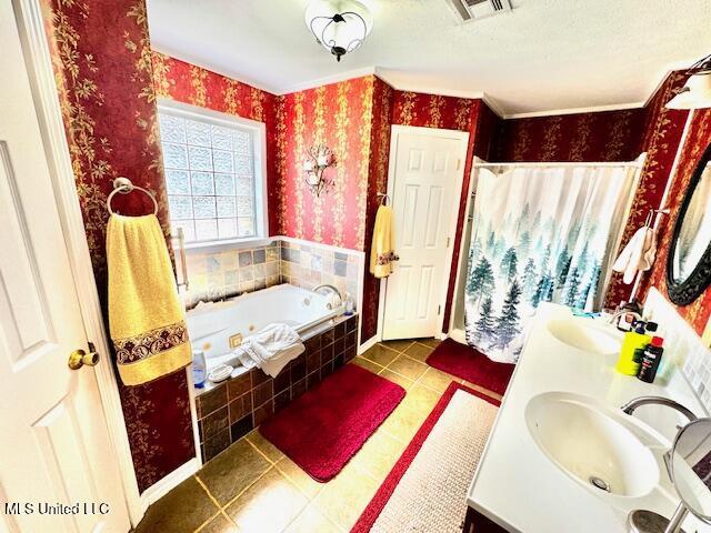 bathroom with a jetted tub, a sink, visible vents, and wallpapered walls