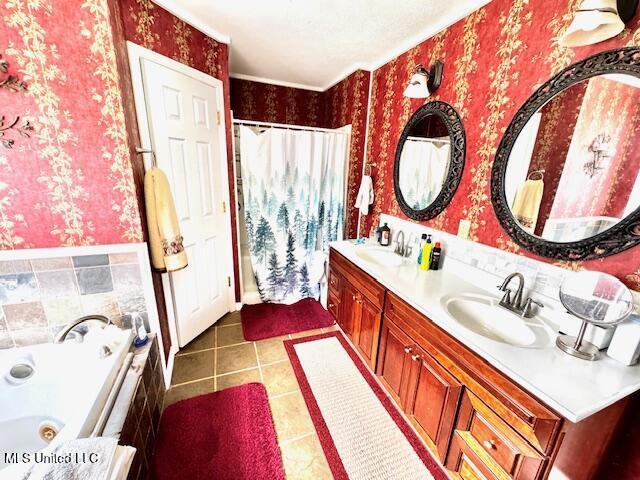 full bath with double vanity, a sink, a tub with jets, and wallpapered walls