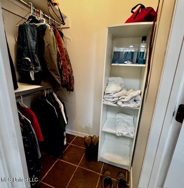 walk in closet with dark tile patterned floors