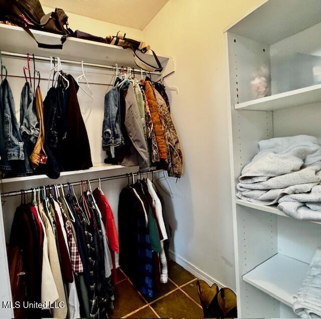 walk in closet with dark tile patterned flooring