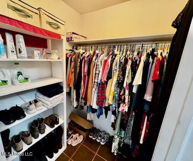 walk in closet featuring dark tile patterned flooring